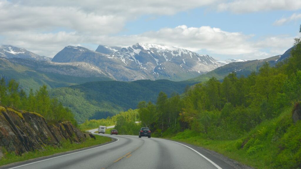 Cars on a road and high mountains in the background