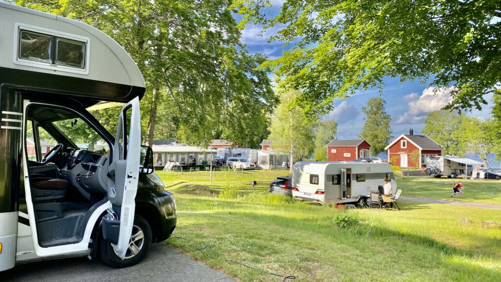 Husbil och husvagnar på campingplats.